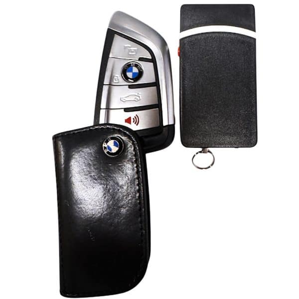 Black and silver car key with leather cover on a white background.
