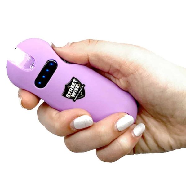 Hand holding a pink self-defense stun gun for personal safety.