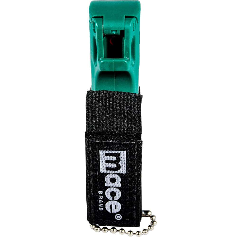 Green Mace pepper spray with black holder and keychain for personal self-defense and safety.