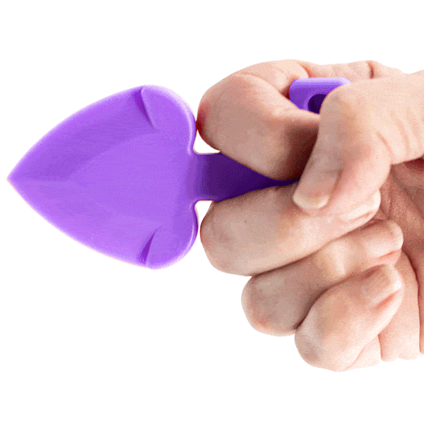 Hand holding a purple garden trowel on a pink background, showcasing grip and tool design.