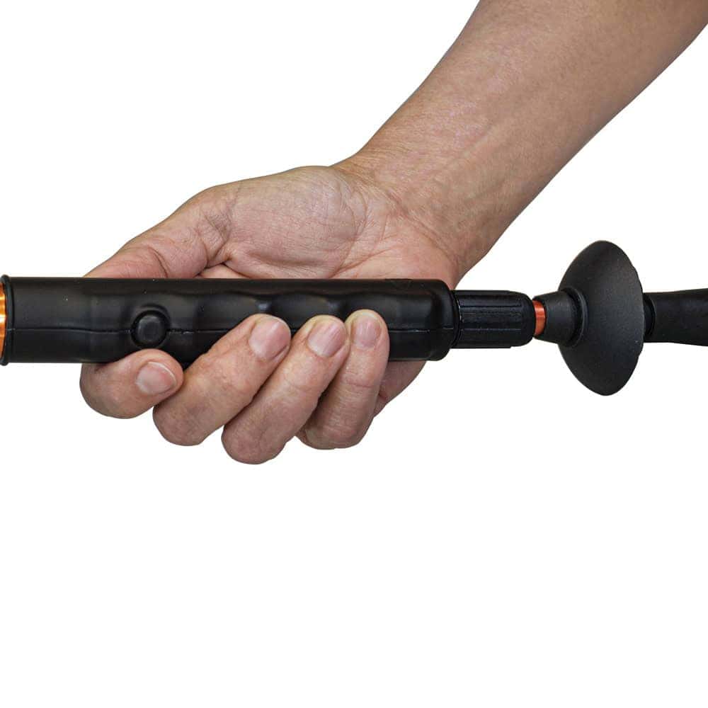 Hand holding a black electric spin scrubber, showing ergonomic grip and power button.
