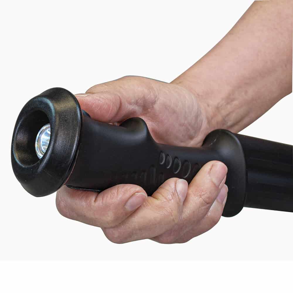 Hand gripping a black flashlight baton, highlighting secure grip and utility features.