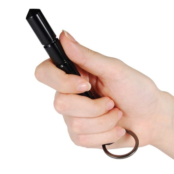 Hand holding black kubotan keychain for self-defense, close-up view.