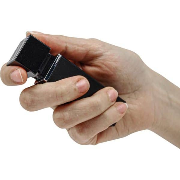 Hand holding a black electric trimmer for grooming, isolated on white background.