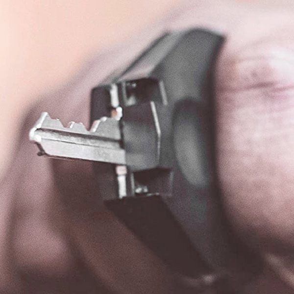 Close-up of a hand holding a car key, highlighting the key teeth and grip.