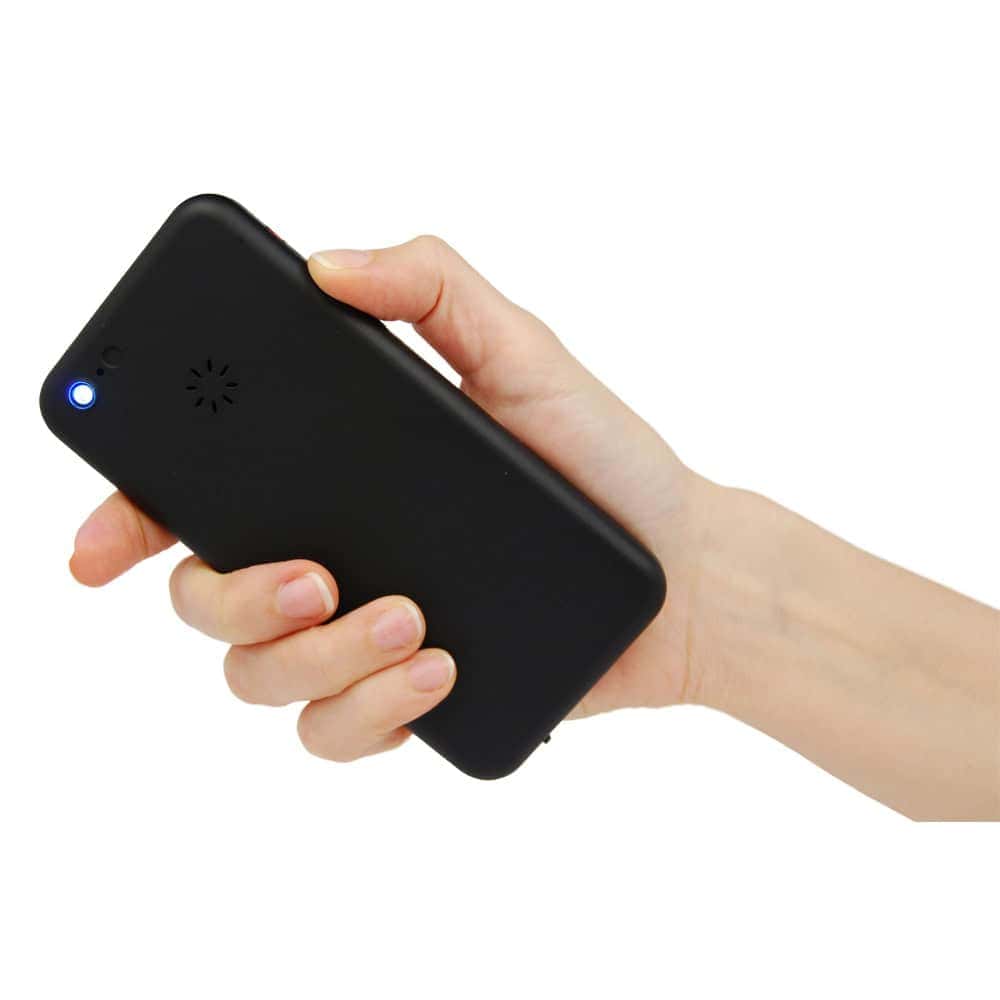 Hand holding a black portable device with a glowing blue indicator light.