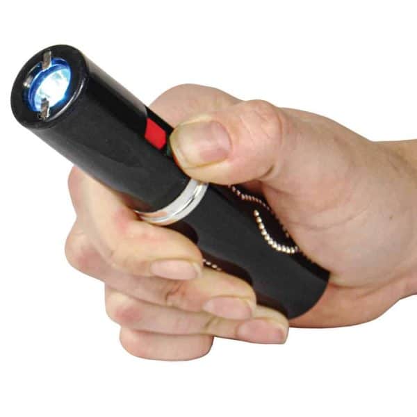 Hand holding a compact stun gun with flashlight, ideal for self-defense and personal safety.