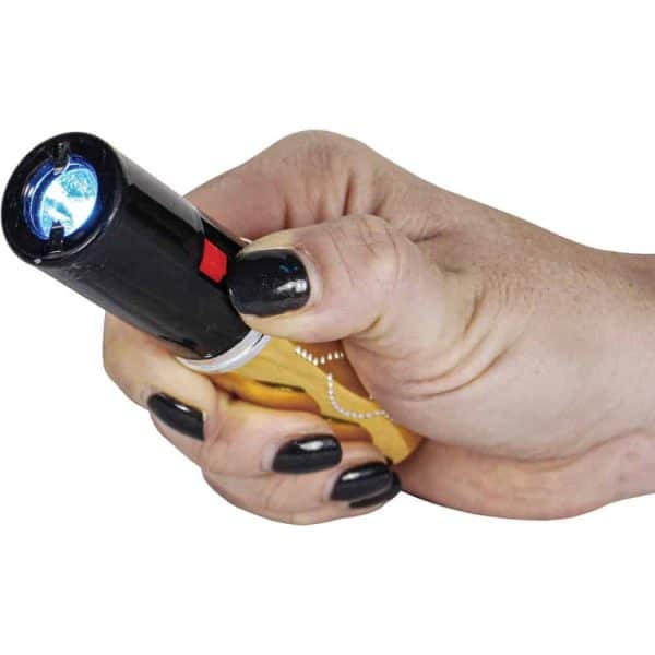 Hand holding stun gun with a bright blue light, showcasing self-defense tool and personal safety device.