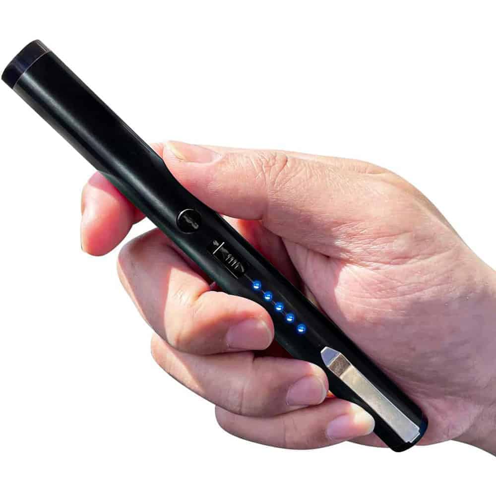 Hand holding a sleek black electronic gadget with LED indicators, resembling a pen-shaped device.