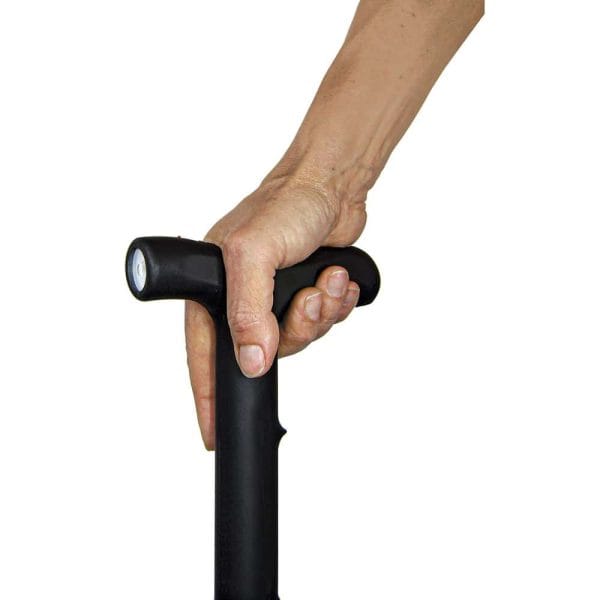 Hand gripping a black cane handle with light, providing support and stability.