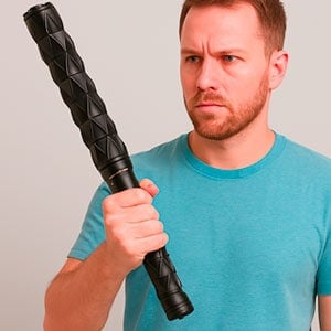 Man holding a black foam roller bar with a determined expression, wearing a teal shirt against a neutral background.