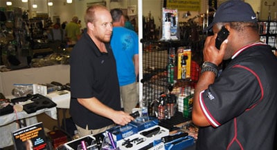 Two men discussing non-lethal self-defense products at a flea market.